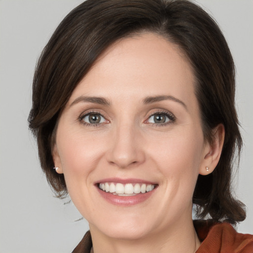 Joyful white young-adult female with medium  brown hair and brown eyes