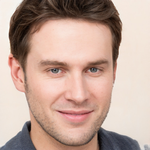 Joyful white young-adult male with short  brown hair and grey eyes