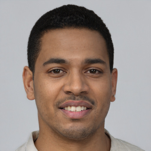 Joyful latino young-adult male with short  black hair and brown eyes
