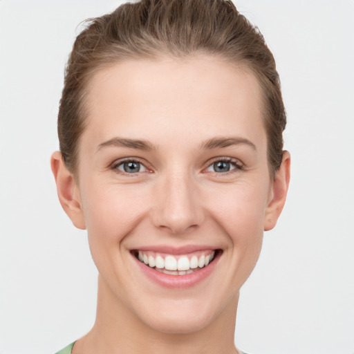 Joyful white young-adult female with short  brown hair and grey eyes