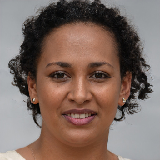 Joyful black adult female with short  brown hair and brown eyes