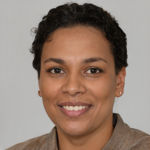 Joyful latino adult female with short  brown hair and brown eyes