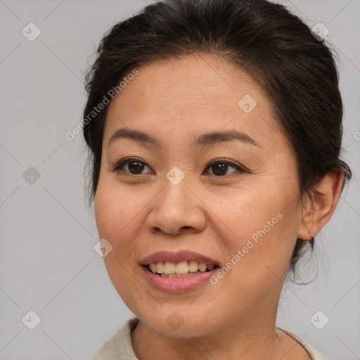 Joyful asian adult female with medium  brown hair and brown eyes