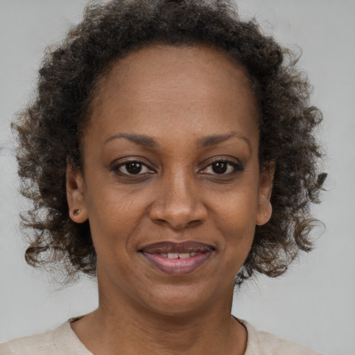 Joyful black adult female with short  brown hair and brown eyes