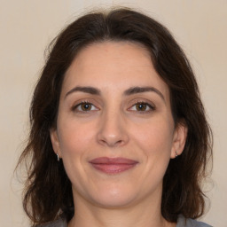 Joyful white adult female with medium  brown hair and brown eyes