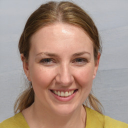 Joyful white young-adult female with medium  brown hair and blue eyes