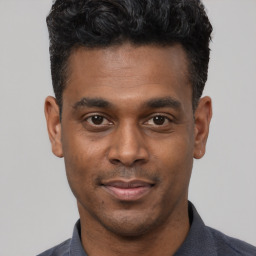 Joyful latino young-adult male with short  black hair and brown eyes