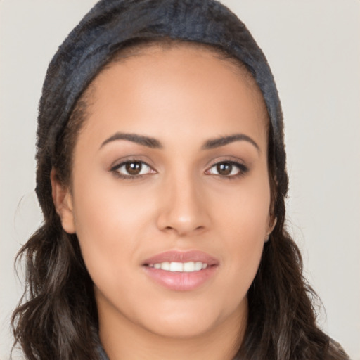 Joyful latino young-adult female with long  brown hair and brown eyes