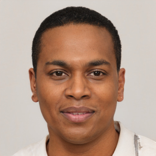 Joyful black young-adult male with short  black hair and brown eyes