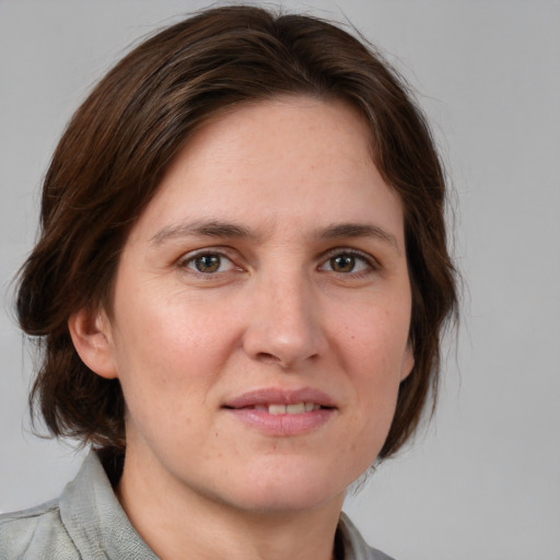 Joyful white adult female with medium  brown hair and grey eyes