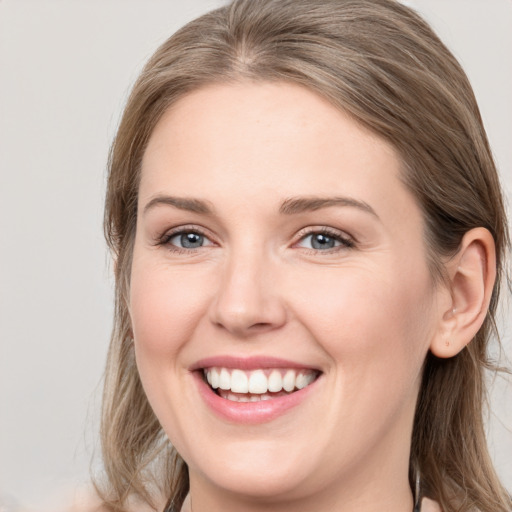 Joyful white young-adult female with long  brown hair and grey eyes