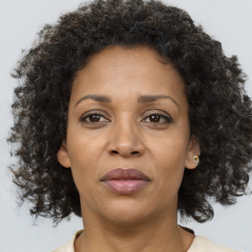 Joyful black adult female with medium  brown hair and brown eyes