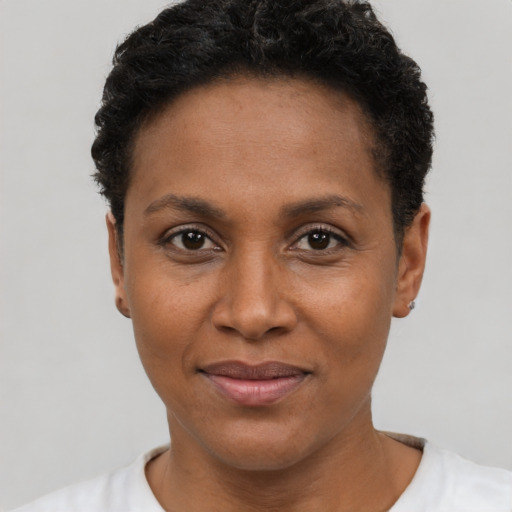 Joyful black young-adult female with short  black hair and brown eyes