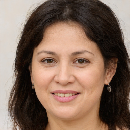 Joyful white adult female with long  brown hair and brown eyes