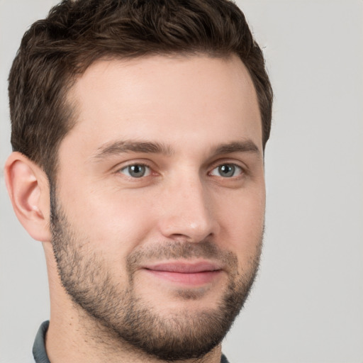 Joyful white young-adult male with short  brown hair and grey eyes