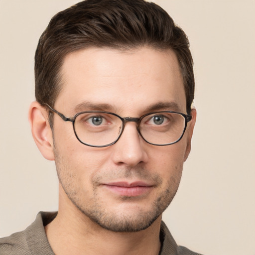 Joyful white young-adult male with short  brown hair and grey eyes