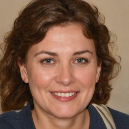 Joyful white adult female with medium  brown hair and blue eyes