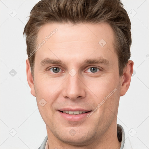 Joyful white young-adult male with short  brown hair and grey eyes