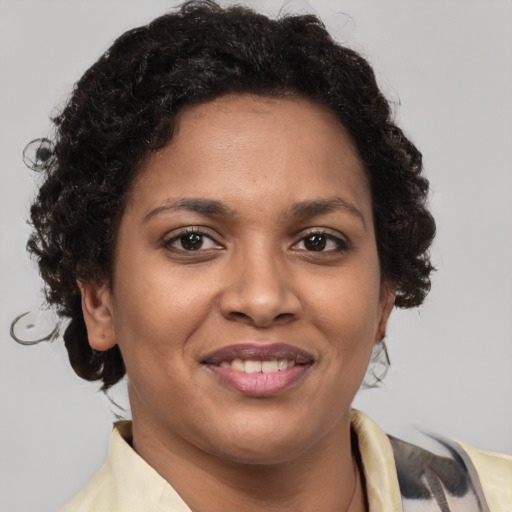 Joyful black young-adult female with short  brown hair and brown eyes