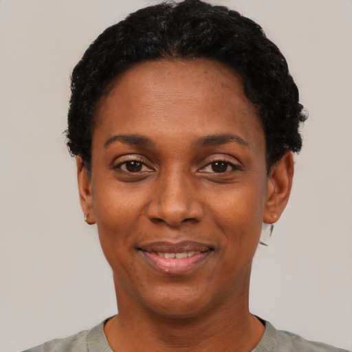 Joyful black young-adult female with short  black hair and brown eyes