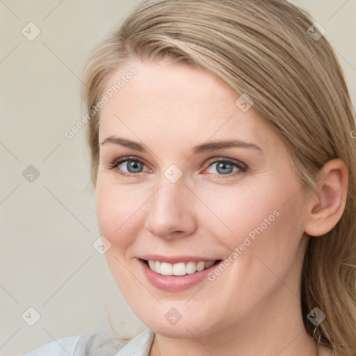 Joyful white young-adult female with long  brown hair and blue eyes