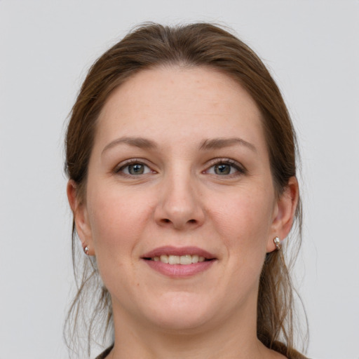 Joyful white young-adult female with long  brown hair and grey eyes