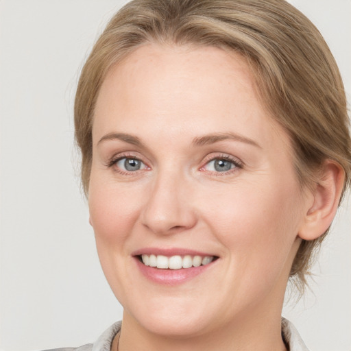 Joyful white young-adult female with medium  brown hair and blue eyes