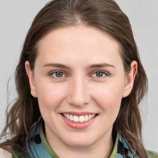 Joyful white young-adult female with long  brown hair and brown eyes