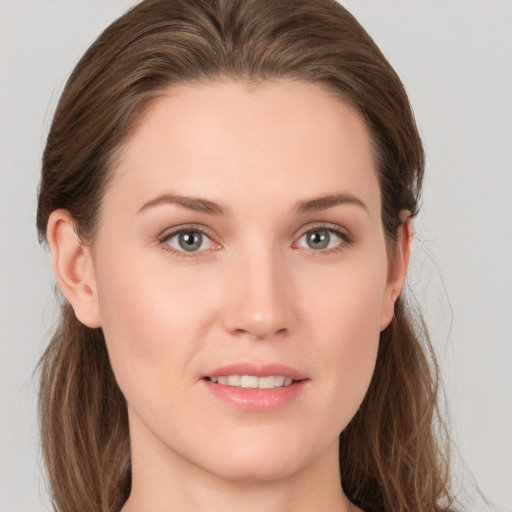 Joyful white young-adult female with long  brown hair and grey eyes