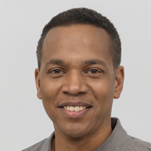 Joyful black young-adult male with short  black hair and brown eyes