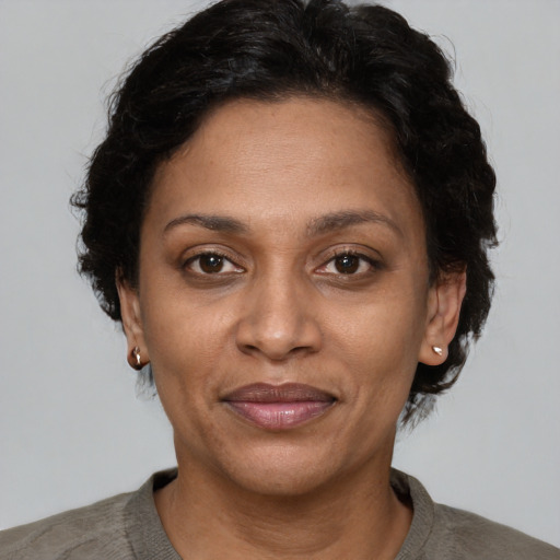 Joyful latino adult female with short  brown hair and brown eyes