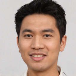 Joyful asian young-adult male with short  brown hair and brown eyes