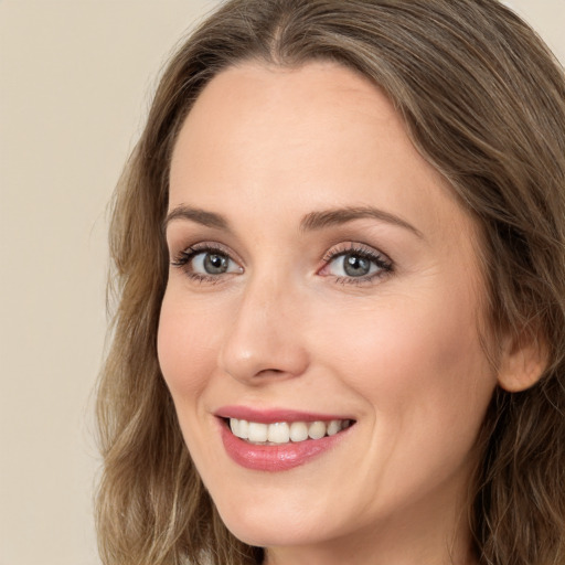 Joyful white young-adult female with long  brown hair and green eyes