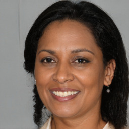 Joyful black adult female with medium  brown hair and brown eyes