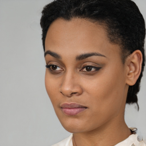 Joyful black young-adult female with short  black hair and brown eyes