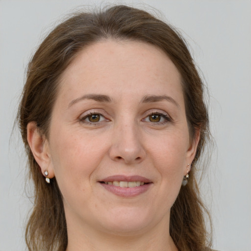 Joyful white adult female with long  brown hair and green eyes