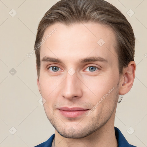 Joyful white young-adult male with short  brown hair and grey eyes