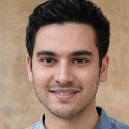 Joyful white young-adult male with short  black hair and brown eyes