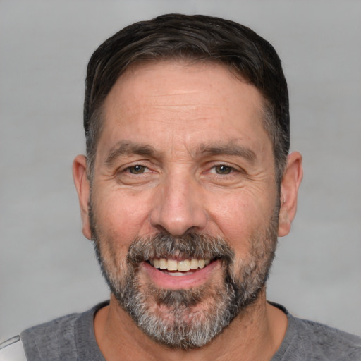 Joyful white adult male with short  black hair and brown eyes