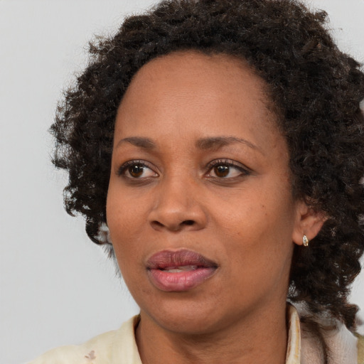 Joyful black adult female with medium  brown hair and brown eyes