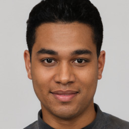 Joyful latino young-adult male with short  black hair and brown eyes