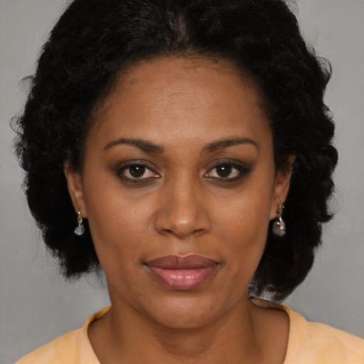 Joyful latino adult female with medium  black hair and brown eyes
