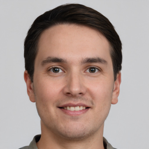 Joyful white young-adult male with short  brown hair and grey eyes