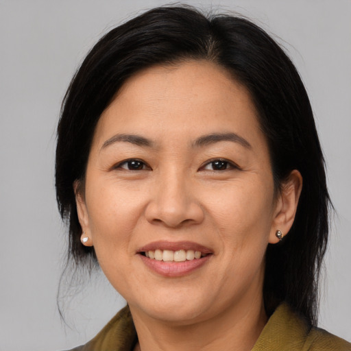 Joyful asian adult female with medium  brown hair and brown eyes