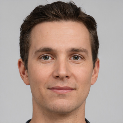 Joyful white young-adult male with short  brown hair and grey eyes