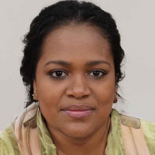 Joyful black young-adult female with short  brown hair and brown eyes