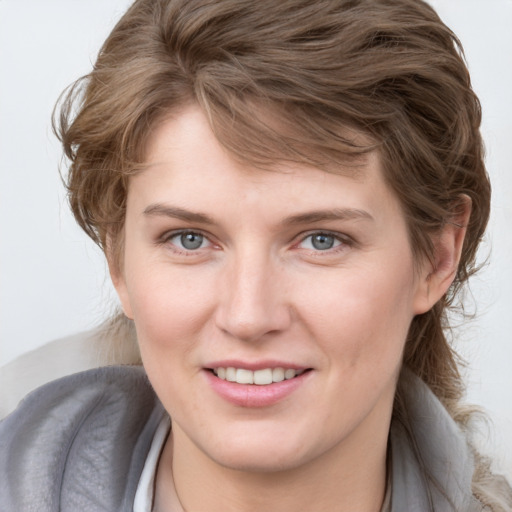 Joyful white young-adult female with medium  brown hair and blue eyes