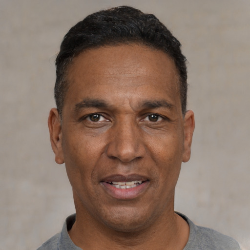 Joyful black adult male with short  black hair and brown eyes