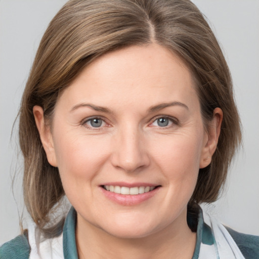 Joyful white adult female with medium  brown hair and grey eyes