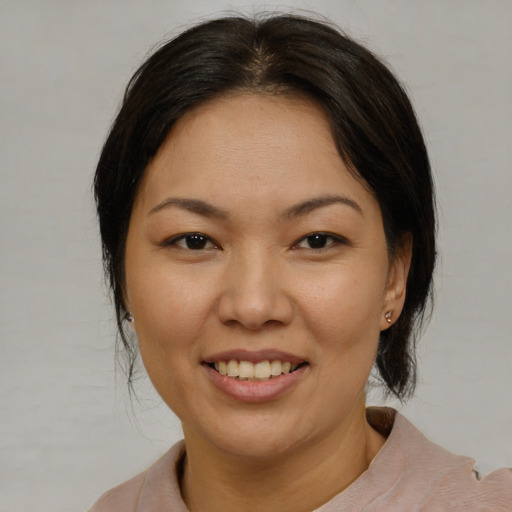 Joyful asian adult female with medium  brown hair and brown eyes
